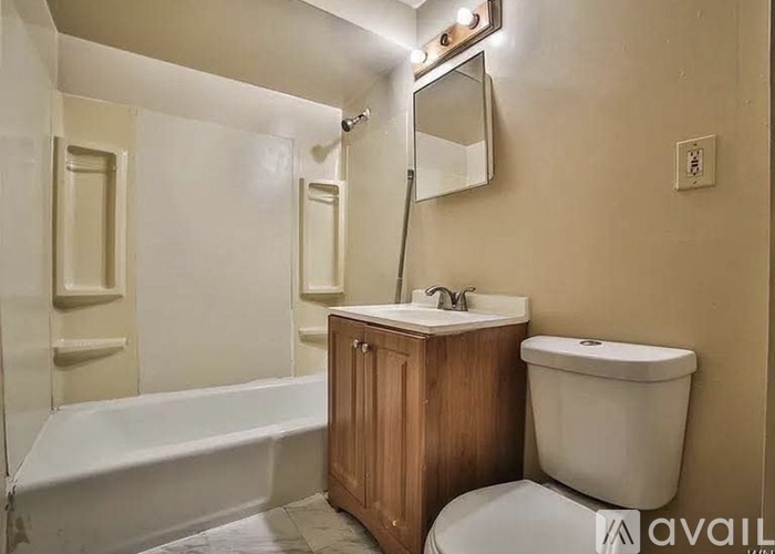 A bathroom with a white tub, sink, and toilet.