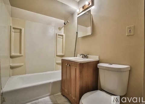 A bathroom with a white tub, sink, and toilet.