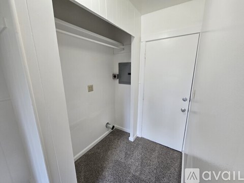 A white door is in a white room with a grey carpet.