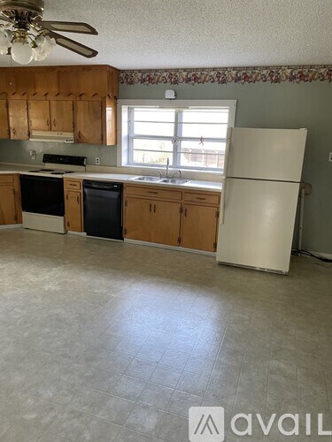 A kitchen with wooden cabinets and a white refrigerator.