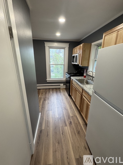 A kitchen with wooden floors and white appliances.
