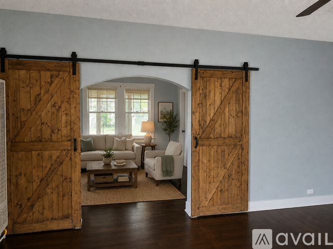 A room with a sliding barn door and a couch.