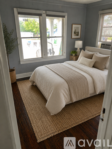 A bedroom with a large bed and a window overlooking a street.