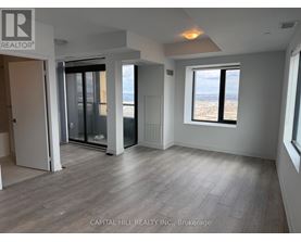 A spacious room with a view of the city through a large window.