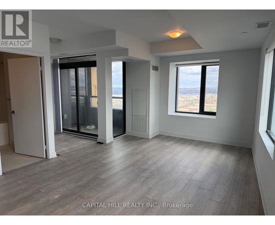 A spacious room with a view of the city through a large window.