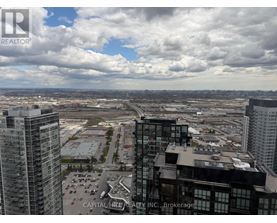 A view from a high-rise building showing a parking lot and other buildings.