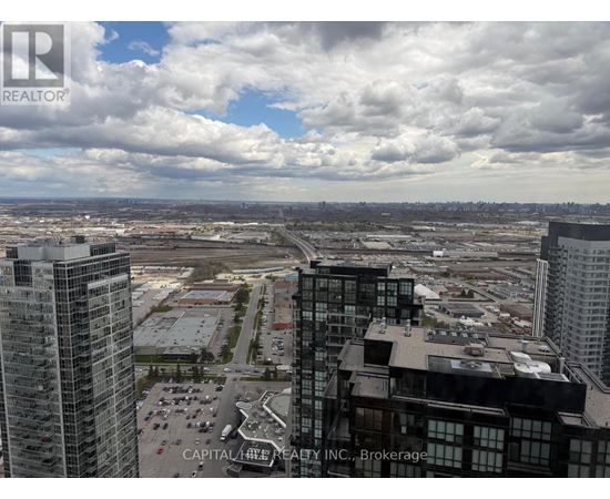 A view from a high-rise building showing a parking lot and other buildings.
