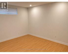 A room with wooden flooring and a window with blinds.