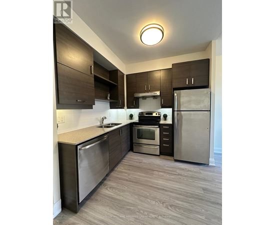 A modern kitchen with stainless steel appliances and wooden cabinets.