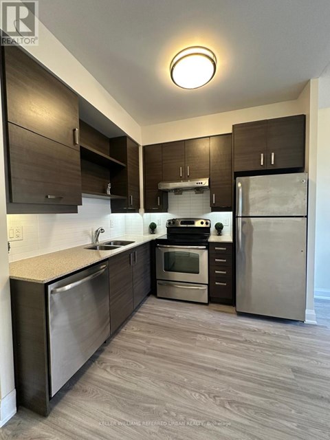 A modern kitchen with stainless steel appliances and wooden cabinets.