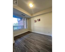 A room with a window and two pictures on the wall.