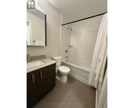 A bathroom with a toilet, sink, and bathtub.