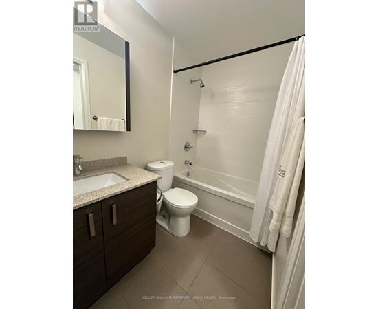 A bathroom with a toilet, sink, and bathtub.
