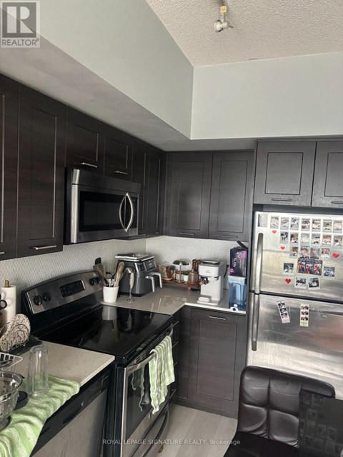 A kitchen with black cabinets and a black counter top.