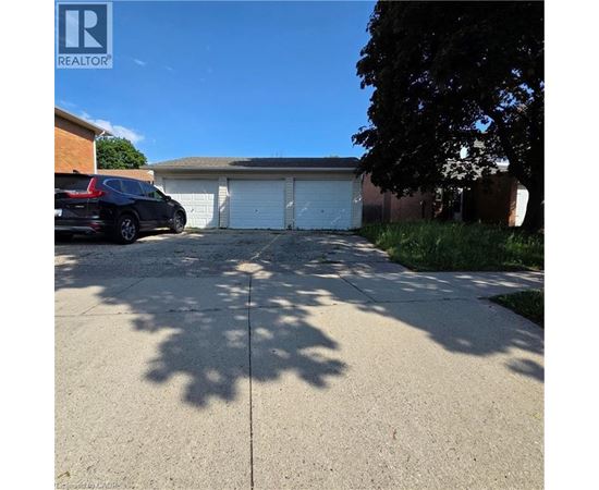 A black car is parked in front of a garage.