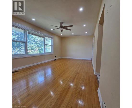 A room with wooden flooring and a ceiling fan.