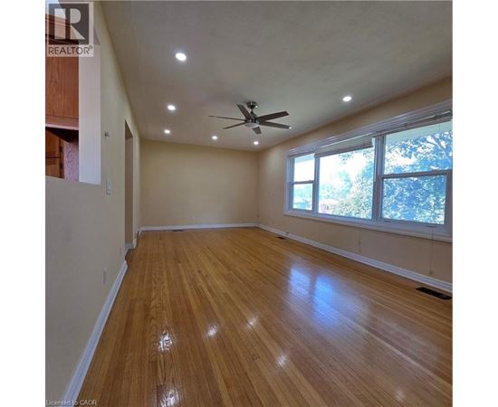 A room with wooden flooring and a ceiling fan.