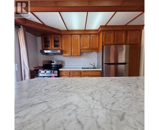 A kitchen with wooden cabinets and a marble countertop.