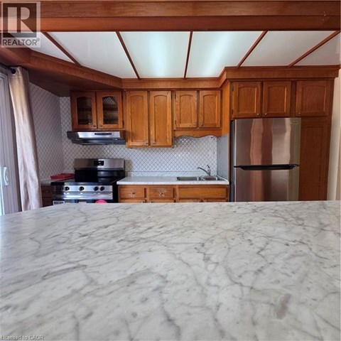 A kitchen with wooden cabinets and a marble countertop.