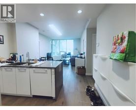 A kitchen with white cabinets and a black countertop.