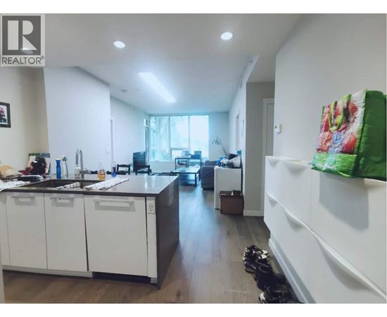 A kitchen with white cabinets and a black countertop.