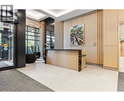 A reception area with a wooden counter and a painting on the wall.