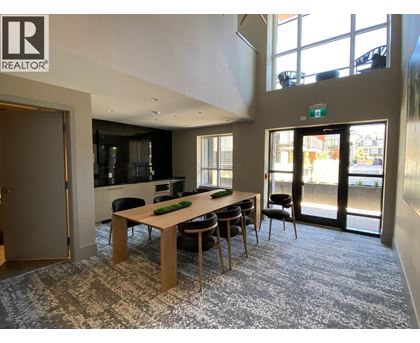 A conference room with a long table and chairs, and a view of the outside through the glass doors.