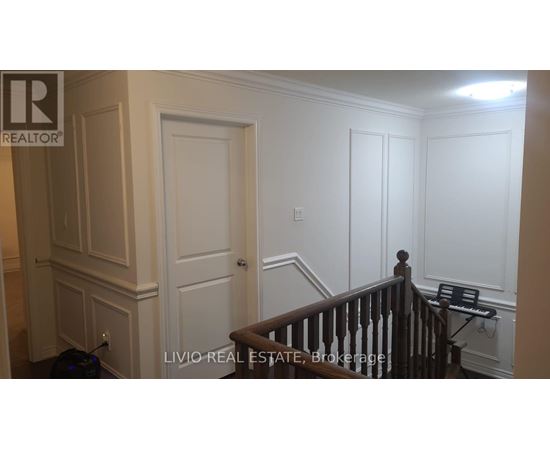 A room with white walls and a wooden staircase.