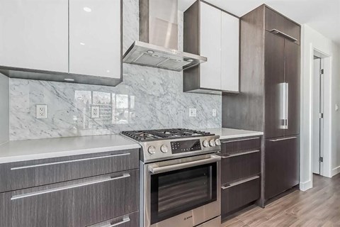 A modern kitchen with a stove top oven and a refrigerator.