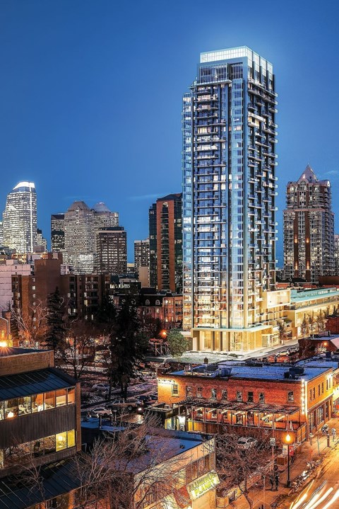 A cityscape at night with a tall blue building in the foreground.
