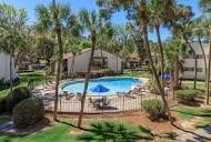 A pool surrounded by a fence and trees.