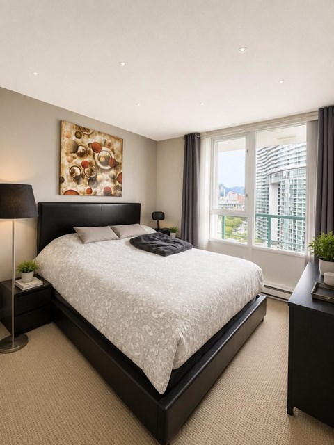 A bedroom with a large bed and a painting on the wall.