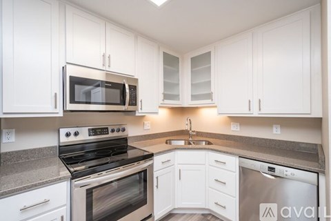 A kitchen with white cabinets and a stainless steel dishwasher.