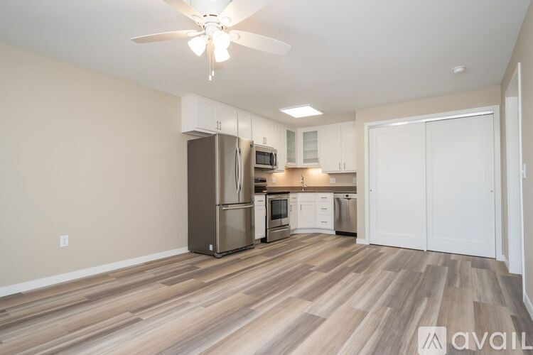 A kitchen with a refrigerator, microwave, and oven.
