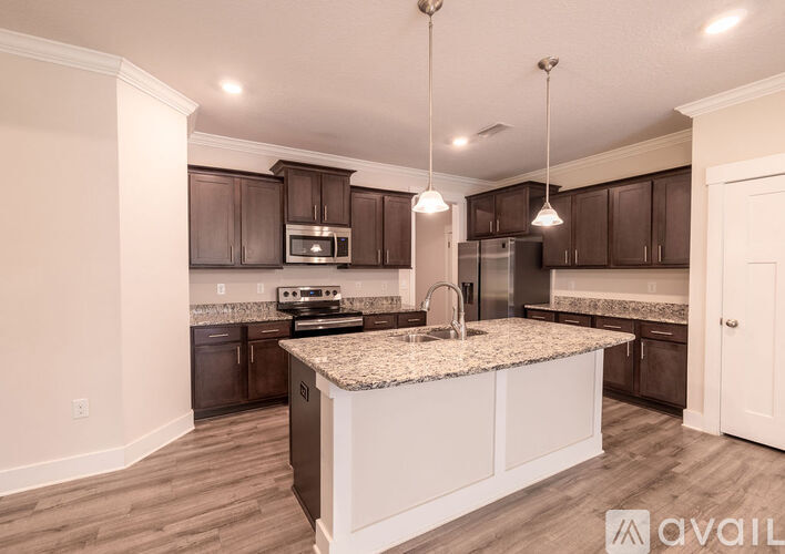 A kitchen with brown cabinets and a granite countertop.