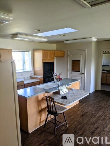 A kitchen with a marble countertop and a chair in front of it.