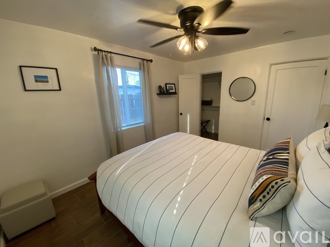 A bedroom with a large bed and a ceiling fan.