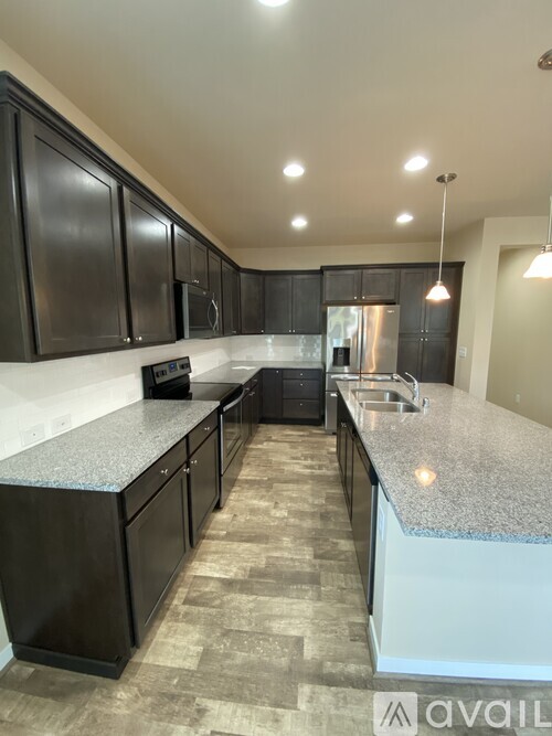 A kitchen with black cabinets and granite countertops.