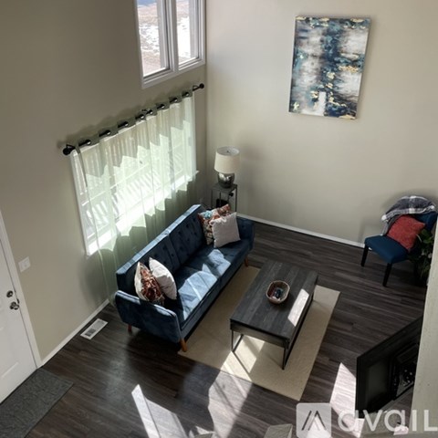 A living room with a blue couch and a coffee table.