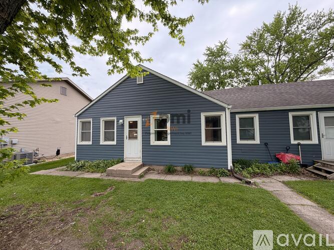 A blue house with a white door and windows is for sale.