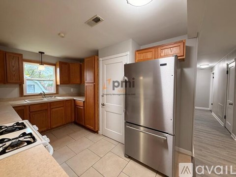 A kitchen with a stove top oven and a refrigerator.