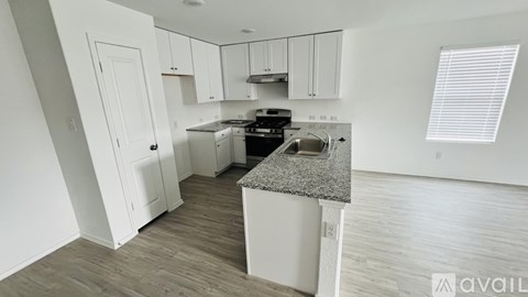 A kitchen with white cabinets and a granite countertop.