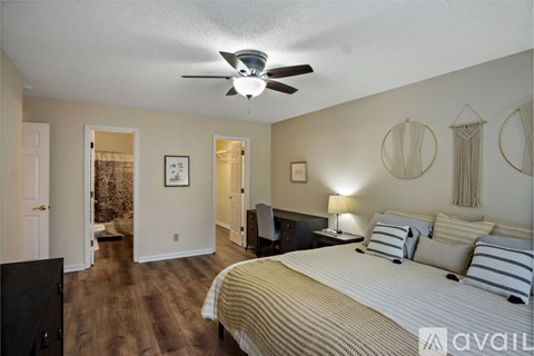A bedroom with a large bed and a ceiling fan.