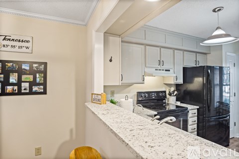 A kitchen with a fridge, stove and oven.