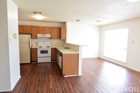 A kitchen with wooden floors and white appliances.