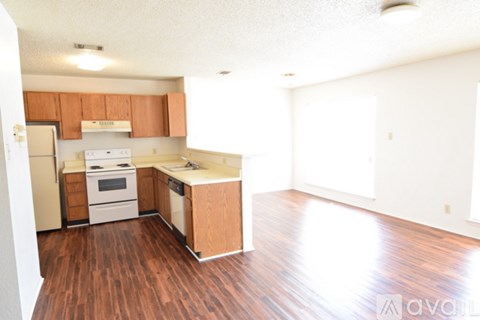 A kitchen with wooden floors and white appliances.