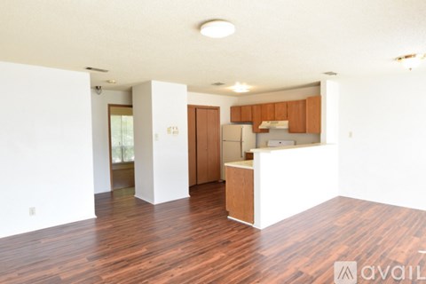 A spacious living room with wooden floors and white walls.
