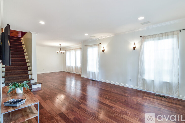 A living room with wooden floors and a staircase.