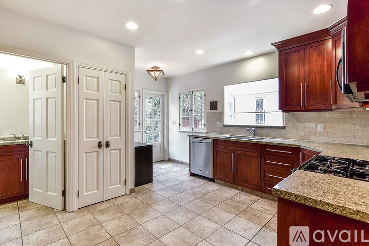 A kitchen with white cabinets and a granite countertop.