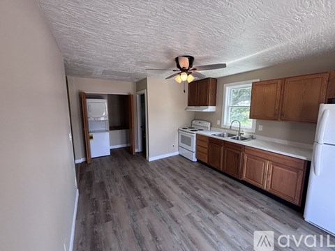 A kitchen with wooden floors and white appliances.